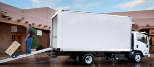 A man unloading boxes from a Isuzu box truck sitting in front of a house